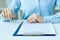 Hands of business woman signing the contract document with pen on desk close-up. Selective focus image on sign a