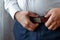 Hands of a businessman, close-up, fastens a belt on trousers