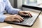 Hands of businesswoman typing on a laptop keyboard, she is using a messaging program to talk to a business partner who is opening