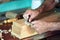 Hands of a cabinetmaker sanding a piece of wood