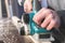 The hands of a carpenter working woodworking power tools. Close up of the work of the electric planer