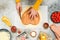 Hands of a caucasian teenage girl in an apron cut out the dough in the shape of a heart for pizza.