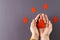 Hands of caucasian woman cupping blood drop, with blood drops on grey background, copy space