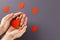 Hands of caucasian woman cupping blood drop, with blood drops on grey background, copy space