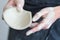 hands of the ceramist shows the cut of the bowl. master demonstrates the quality of his work