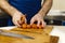 Hands of chef cutting peeled carrots