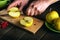 Hands of a chef with a knife cutting fresh apples on a cutting board. Apple diet to strengthen immunity