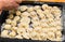 The hands of the chef placed the dumplings on a baking sheet. Handmade homemade Russian Siberian dumplings.