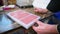 Hands of chef preparing tempered liquid chocolate pink in bar mould in a factory