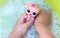 Hands of a child bathing a doll in soapy water, close-up, top view