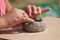 hands of child making clay pottery bowl in outdoor