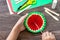 In the hands of a child Paper Fan watermelon on a wooden table. Childrens art project, handmade, crafts for children.