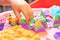Hands of a child playing with multicolored kinetic sand