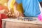 Hands of children are helping putting coins into piggy bank on white background