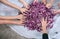 Hands of children working with pile of purple cabbage.