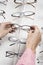 Hands Choosing Eyeglasses From Rack