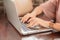 Hands close up of businesswoman working on laptop on table in cafe