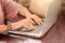 Hands close up of businesswoman working on laptop on table in cafe