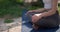 Hands close-up - Young caucasian woman in sportswear sits on yoga mat outdoor and meditating
