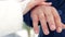 Hands closeup couple bride groom hold the ring for