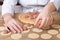 Hands closeup lay out meat balls on dough rounds