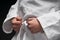 Hands closeup - teenager dressed in martial arts clothing posing on a dark gray background, a sports concept