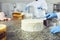 Hands confectioner spreads custard on a white cake on the table in the pastry shop