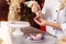 Hands with confectionery bag squeezing cream to macarons shells