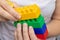 Hands constructing from colorful toy plastic bricks, blocks for building on white background
