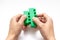 Hands constructing from colorful toy plastic bricks, blocks for building on white background