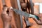 Hands of construction worker sharpens a knife on sanding machine