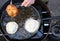 Hands of cook frying big pancakes in a pan of hot oil in a stree