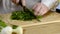 Hands of the cook knife big kitchen a fresh green parsley on a chopping board from a tree