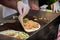 Hands of cook preparing fajita wrap with beef and vegetable salad. Mexican food. Party food.