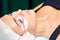 Hands of cosmetologist using eyelash brush