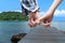 Hands of couple holding finger crossed with wood bridge on the sea. Summertime relax in holiday for romantic couple.