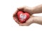 Hands covering Polish coat of arms on a red heart on white background