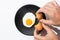 Hands cracking Fried egg on black plate on  white background. Cooking and food concept