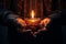 Hands cradling a candle, with its soft, warm glow as the sole source of light, symbolizing the power of a single flame to dispel