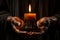 Hands cradling a candle, with its soft, warm glow as the sole source of light, symbolizing the power of a single flame to dispel