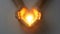 Hands cradling a glowing light in a heart shape
