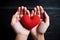 Hands cradling a red heart symbolizing love and care