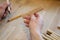 Hands of the craftsman carve with a gouge. Wood carving. Wood carving set on a wooden table.