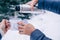 Hands with cups of tea and thermos flask in snowy winter forest