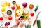 Hands cut different fresh vegetables on cutting board for cooking vegetable stew. White background top view