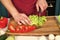 Hands cut green salad, red pepper, vegetables with knife