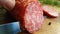 Hands cut sausage salami kitchen on a wooden background