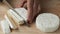 Hands cutting Camembert cheese. Farm product