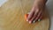 Hands cutting carrots on a cutting board. Woman cutting carrot on table, close-up