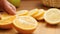 Hands cutting fresh orange on wood plate